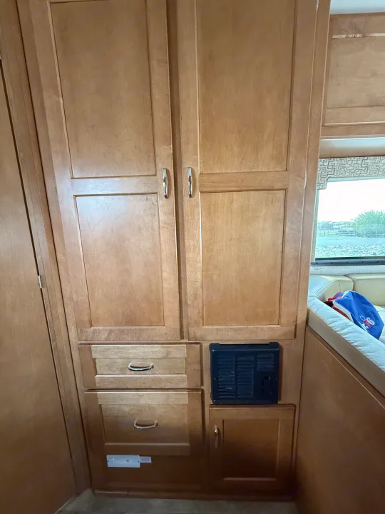 Compact RV rental interior: light wood cabinets, drawers, and a vent for heating/cooling, optimizing space and storage.. Winnebago Minnie Winnie 2016