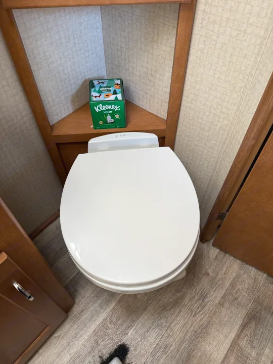 Inside an **rv rental**: a small bathroom with a white toilet, corner shelf, and Kleenex boxes.. Winnebago Minnie Winnie 2016