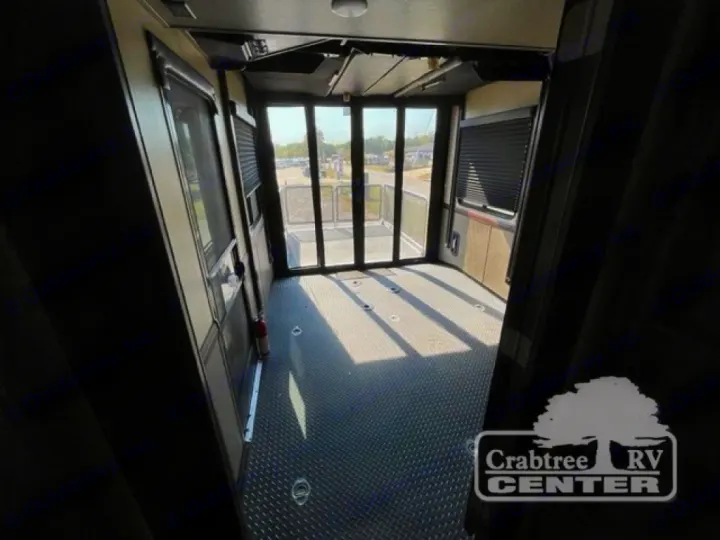 Spacious RV rental garage with durable flooring and large rear doors, ideal for cargo.. Heartland Road Warrior 425 2016