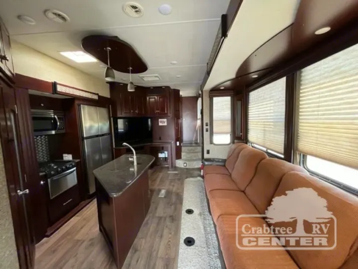 Spacious RV rental interior featuring a full kitchen with island, living area with a long sofa, and ample cabinetry.. Heartland Road Warrior 425 2016