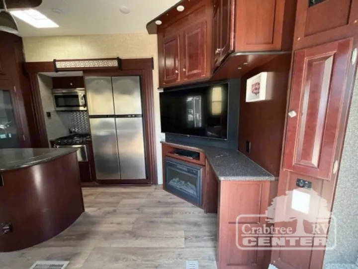 RV rental interior: kitchen with stainless steel fridge, stove, microwave, plus TV and electric fireplace.. Heartland Road Warrior 425 2016