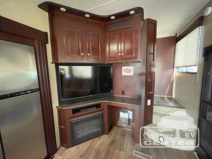 RV rental's spacious living area with a large TV, electric fireplace, and stainless steel refrigerator.. Heartland Road Warrior 425 2016