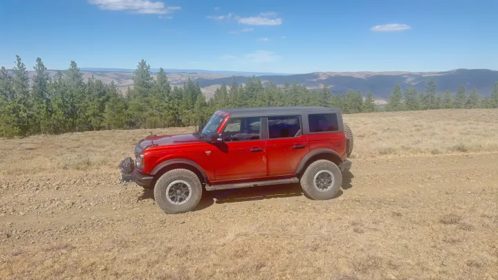 Red Ford Bronco on a scenic off-road trail. Ideal for adventure, think of it as your 'RV rental' exploration vehicle.. Ford Bronco Badlands 2023