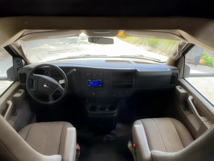 Inside an RV rental: Wide view of the front cabin, showing dashboard, steering wheel, infotainment, and cozy driver/passenger seats.. Forest River Sunseeker 2017
