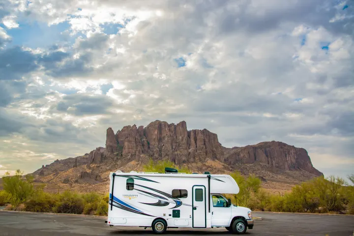 Explore majestic desert landscapes! White RV rental parked before rugged mountains and a dramatic sky.. Nexus Other 2026