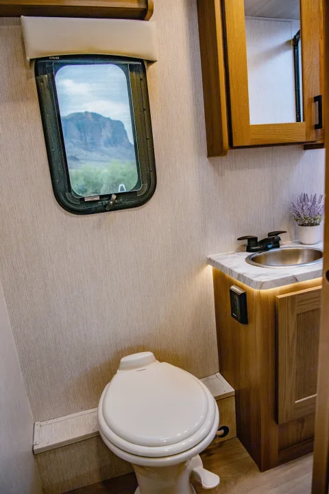 RV rental: This RV bathroom features a compact toilet, vanity with sink, and a window showing a mountain landscape outside.. Nexus Other 2026