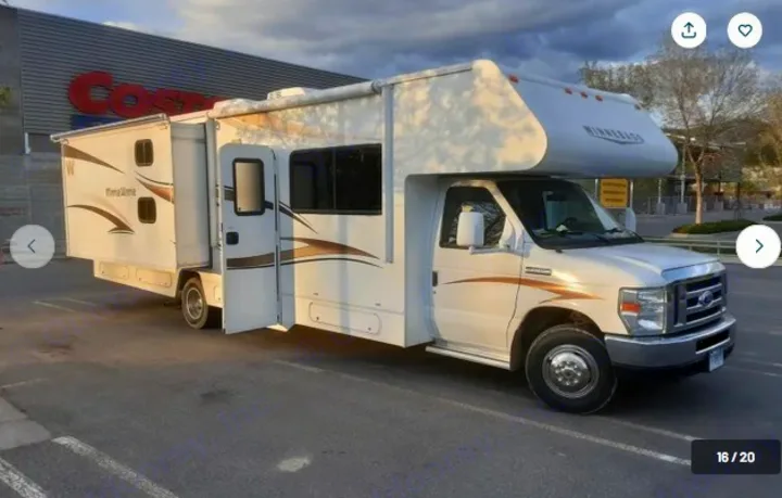 Spacious white RV rental: a Winnebago Minnie Winnie motorhome with extended slide-outs in a parking lot near Costco.. Winnebago Minnie Winnie 2015