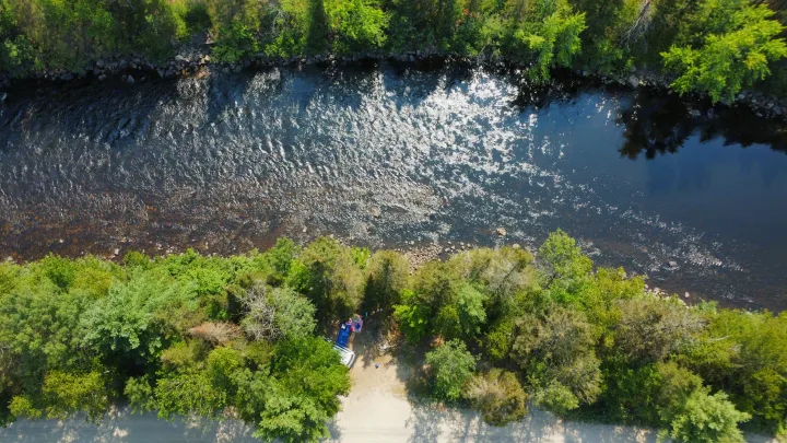 Aerial view of an RV rental on a sunny riverbank campsite, surrounded by green trees. Perfect for outdoor adventures.. Dodge Dodge Grand Caravan GT 2017 2017