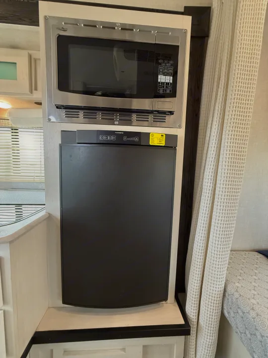 View of a compact High Pointe microwave above a Dometic refrigerator inside an RV rental, perfect for travel.. R-Pod R-Pod Trailer 2021