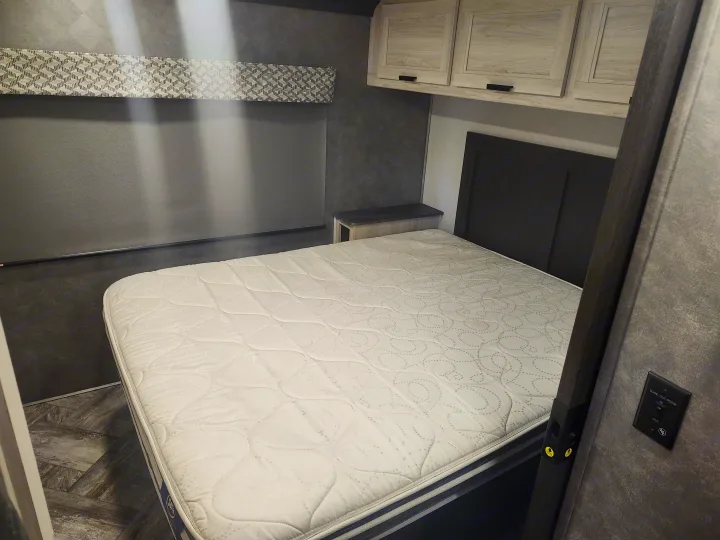 RV rental bedroom with Serta mattress, overhead cabinets, and a slide-out room switch.. Forester LE 2023