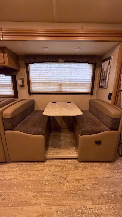Cozy RV rental dinette with comfortable benches and a table, perfect for meals on the road.. Thor Hurricane 2019