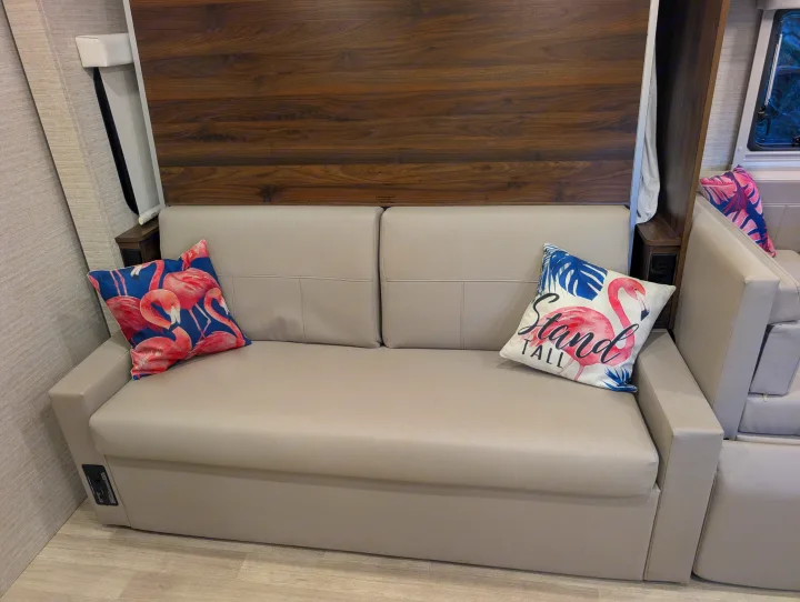 RV rental interior: A modern, comfortable sofa with two vibrant flamingo pillows, offering a cozy spot for your adventures.. Winnebago View 2025