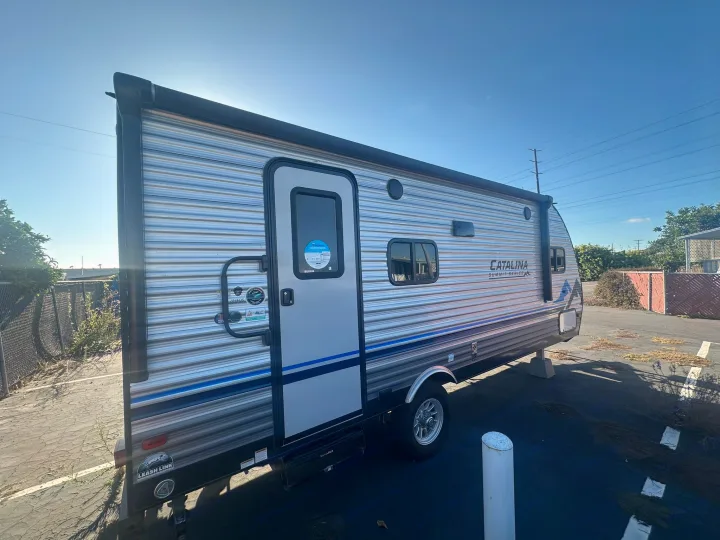 Bright day for an RV rental! A sleek Catalina travel trailer awaits your next outdoor adventure, parked on a sunny lot.. Coachmen Catalina Summit Series 7 2022