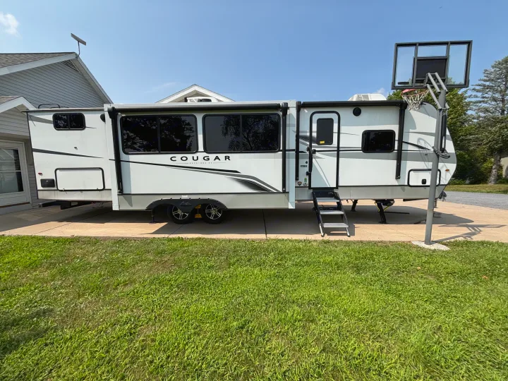 Spacious Cougar Keystone RV travel trailer parked at a residential home, ready for your next RV rental adventure.. Keystone RV Cougar 2023