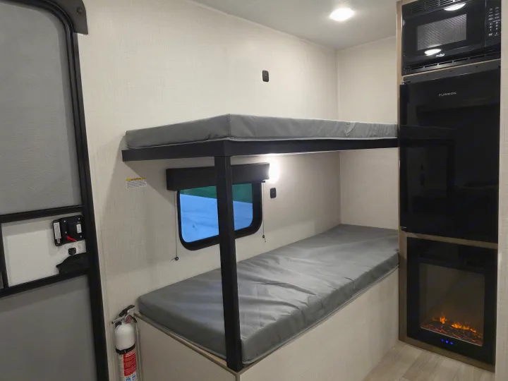 RV rental: Bunk beds, microwave, TV, fireplace, and fire extinguisher for a cozy journey.. Keystone Springdale 2026