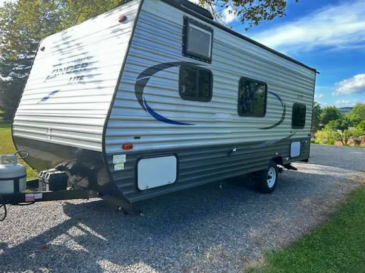 Get ready for adventure with this Zinger Lite RV rental! A travel trailer parked on gravel, featuring a scenic outdoor setting.. Crossroads RV Z-1 Lite 2017