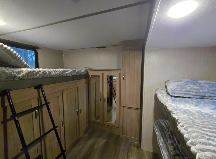 Cozy RV rental interior with bunk beds, ladder access, and ample storage, perfect for family adventures.. Coachmen Forest River Freedom Express Liberty Series M-320 BHDS 2021