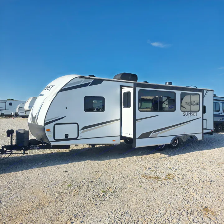 White 'Sunset Trail' travel trailer on a gravel lot, ideal for your next RV rental adventure.. Crossroads RV Sunset Trail Super Lite 2022
