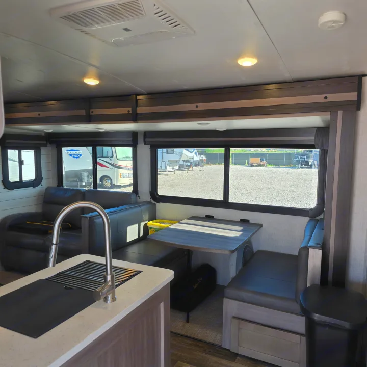 Spacious RV rental interior with a comfy dinette, sofa, and modern kitchen counter. Ideal for your next adventure.. Crossroads RV Sunset Trail Super Lite 2022