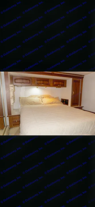 Cozy RV rental bedroom interior with a comfortable bed, overhead cabinets, and reading lights.. Itasca Horizon 2002