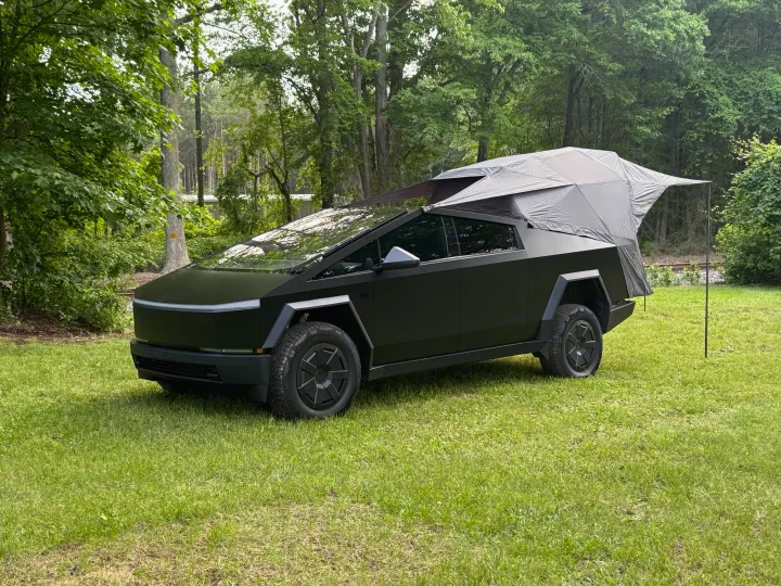 Tesla Cybertruck with a pop-up tent camper, perfect for an rv rental adventure in nature.. Tesla Cybertruck 2025