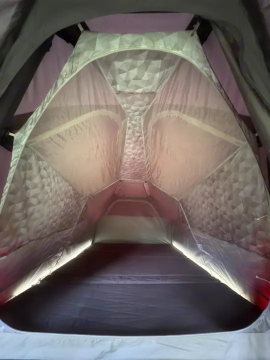 Cozy RV rental pop-up tent interior featuring patterned fabric walls, a plush mattress, and ambient LED lighting.. Tesla Cybertruck 2025