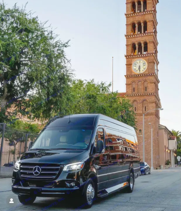 Black Mercedes Sprinter van, a luxury RV rental option, parked on a city street near a historic brick clock tower.. Ultimate Toys Ultimate Coach 2023