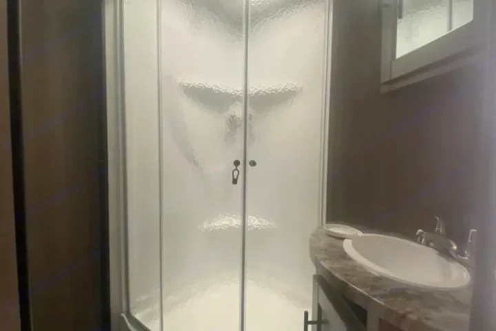 Inside an RV rental: a compact bathroom featuring a frosted glass shower and modern sink vanity. Perfect for road trips.. Crossroads RV Sunset Trail Super Lite 2023