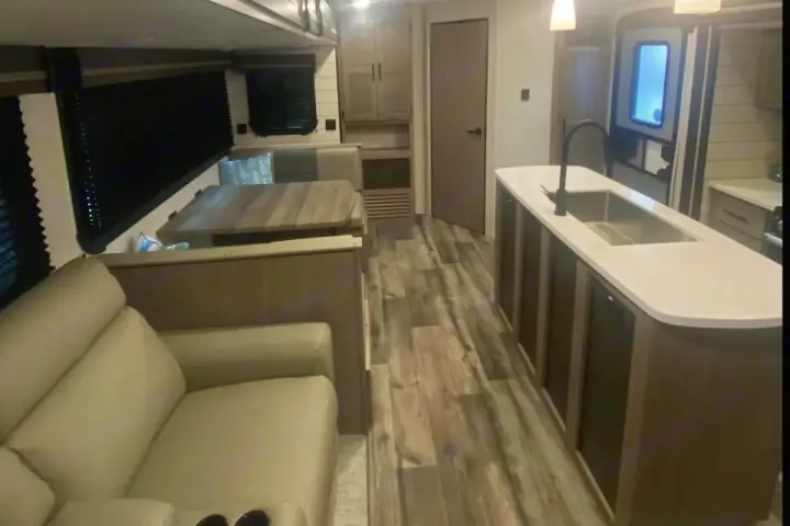 Well-appointed RV rental interior: kitchen island, dining booth, and comfortable living area.. Crossroads RV Sunset Trail Super Lite 2023