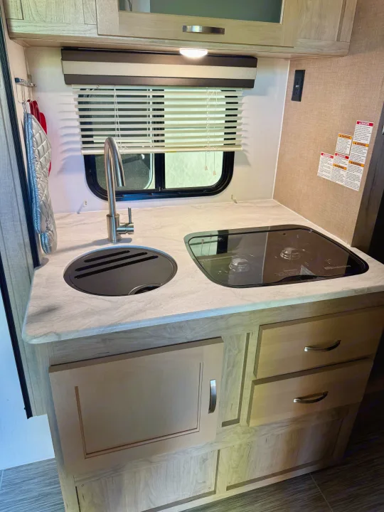 RV rental: well-equipped galley features a sink, 2-burner stovetop, light wood cabinets & counter.. Forest River RPod 189 2019
