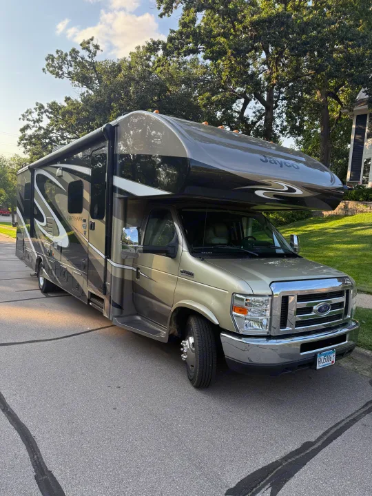 Class C Jayco Greyhawk motorhome RV rental, gold & dark gray, parked on a sunny street.. Jayco Greyhawk 2018