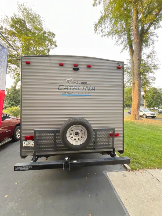 Rear of a Coachmen Catalina Legacy Edition travel trailer from Lazydays RV, featuring a spare tire and cargo rack. Great for rv rental trips!. Forest River Coachmen Catalina Legacy 2021