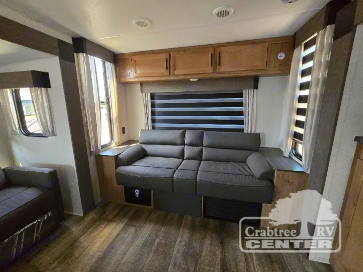 This RV rental offers a comfy living space with a large sofa, wood floors, and bright windows – your perfect home on wheels.. Forest River Cherokee M-274WK 2024