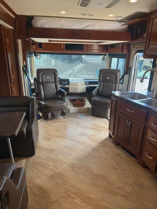 Spacious rv rental interior showing cockpit, overhead bunk, dinette, and kitchen for comfortable travel.. Fleetwood Bounder 2016