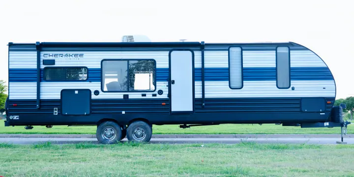 A blue and white Cherokee Limited travel trailer, seen from the side. It's an ideal rv rental for outdoor adventures.. Forest River Cherokee 2020