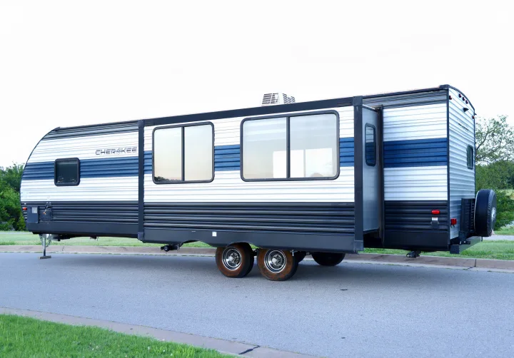 Side view of a white & blue Cherokee travel trailer RV rental, with an extended slide-out. Ready for your next camping adventure!. Forest River Cherokee 2020