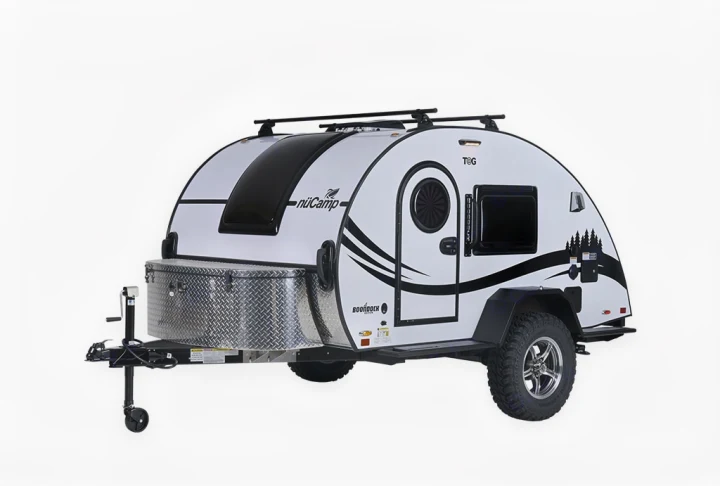 This compact nuCamp T@G teardrop RV rental, a white camper trailer with rugged tires & a roof rack, is ready for adventure.. nuCamp T@G 2023