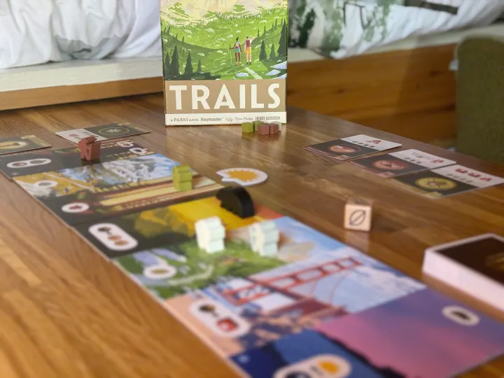 "TRAILS: A Parks Game" set up on a wooden table, an ideal leisure activity for an RV rental getaway.. RAM Promaster 2500 2020