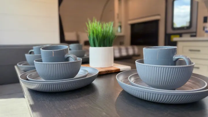 Stylish grey dishes neatly stacked on a table inside a modern RV, perfect for your next RV rental adventure.. jayco 235MBH Jay Flight TT 2025