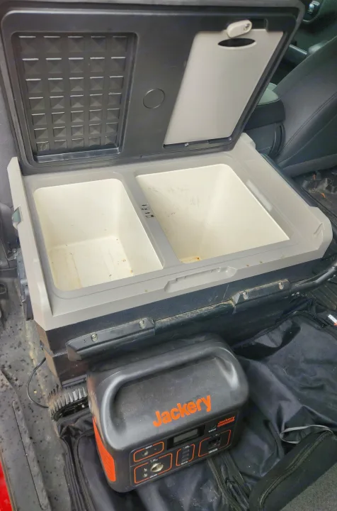 Inside an RV rental: a portable fridge-freezer with two compartments and a Jackery power station, ideal for off-grid adventures.. Chevrolet Silverado 1500 Trail Boss 2020