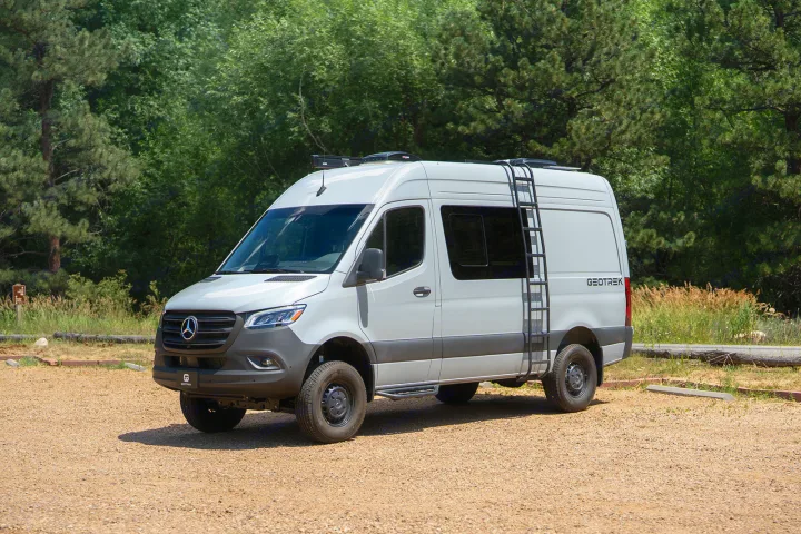 Customized light grey Mercedes Sprinter adventure van with roof ladder, ideal for RV rental exploring.. Geotrek Flatiron Summit 2025