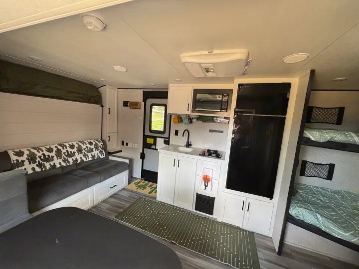 Modern RV rental interior with a functional kitchen, comfortable living area, and bunk beds for family comfort.. Jayco Jay Flight 197MB 2025