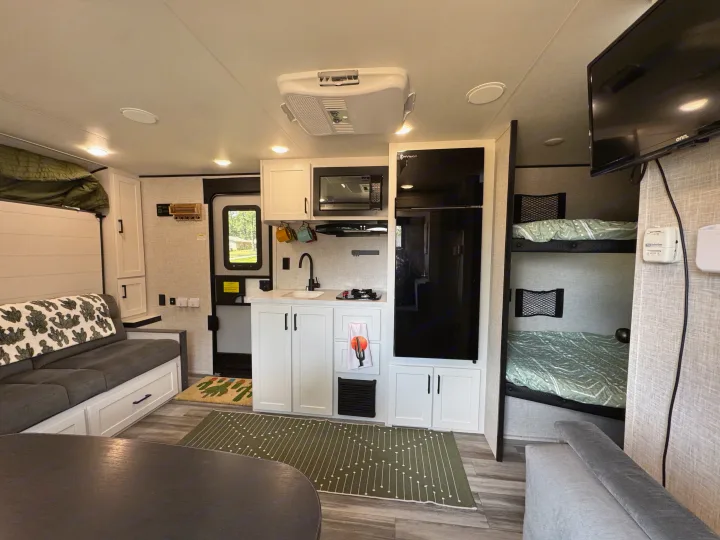 Spacious RV rental interior featuring a modern kitchen, cozy living area with sofa, and bunk beds. Perfect for family adventures.. Jayco Jay Flight 197MB 2025
