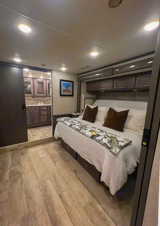 Spacious, modern RV bedroom with storage under the bed, overhead cabinets, and an adjoining bathroom. Ideal for your rv rental comfort.. Thor Motor Coach 2023