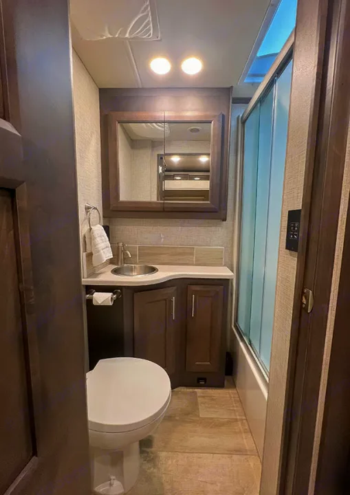 Compact, modern RV rental bathroom with sink, toilet, and shower, ideal for comfortable travel.. Thor Motor Coach 2023