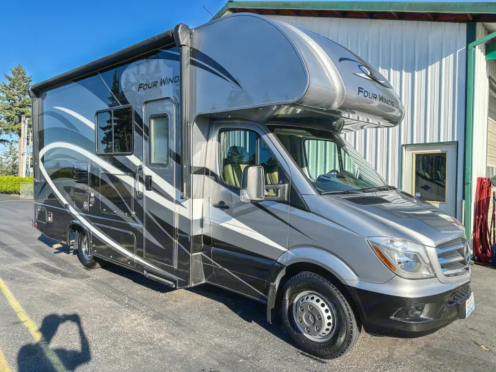 This sleek grey Four Winds RV rental, a modern recreational vehicle, is parked and ready for your next journey.. Thor Four Winds 2019