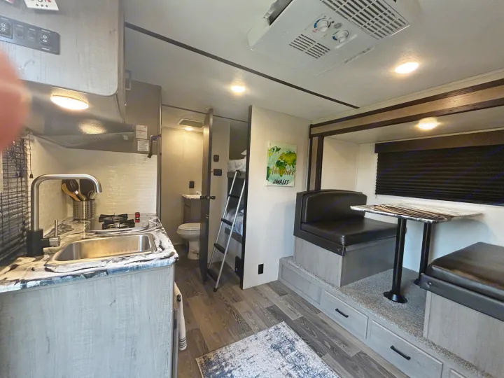Explore this well-equipped RV rental featuring a kitchen, dinette, bathroom, bunk beds, and AC unit for comfortable trips.. Keystone RV Hideout 2021