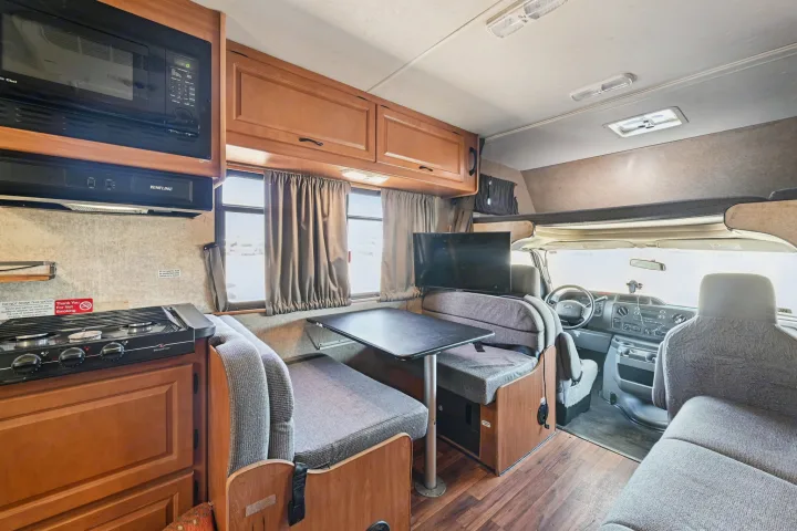 Experience comfort in this rv rental. Interior features a kitchenette with stovetop, microwave, dinette, TV, and driver's area.. Thor Majestic 2012