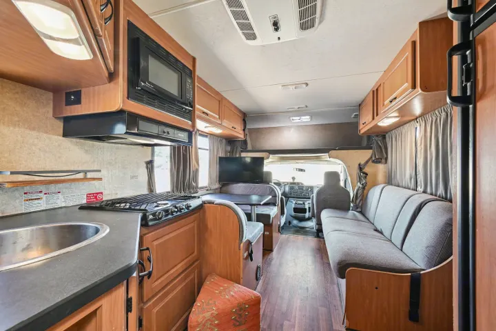 Inside a comfortable rv rental: well-equipped kitchen, dining area, sofa, and front cabin. Ready for your adventures.. Thor Majestic 2012