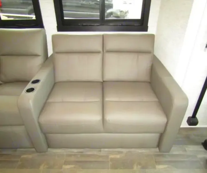 RV rental: Light gray reclining sofa with cup holders, offering comfortable seating inside.. Jayco Precept 2025
